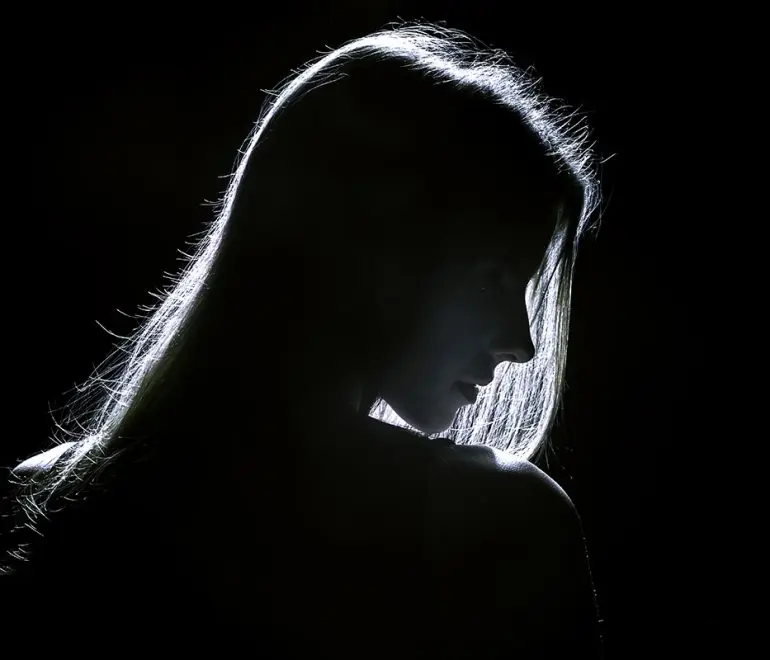 sad woman profile silhouette in dark